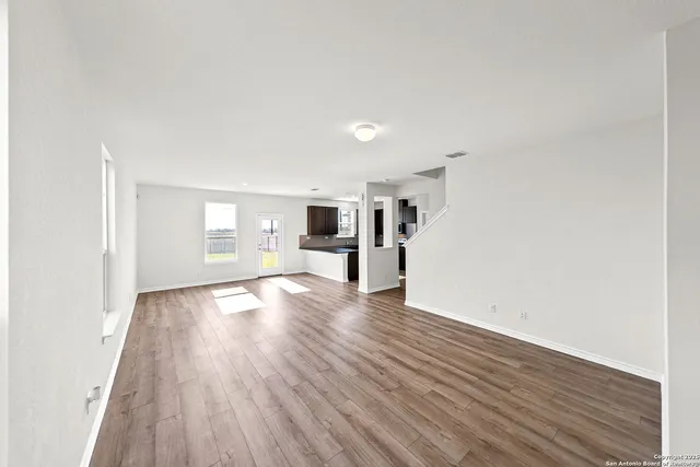 a view of empty room with wooden floor