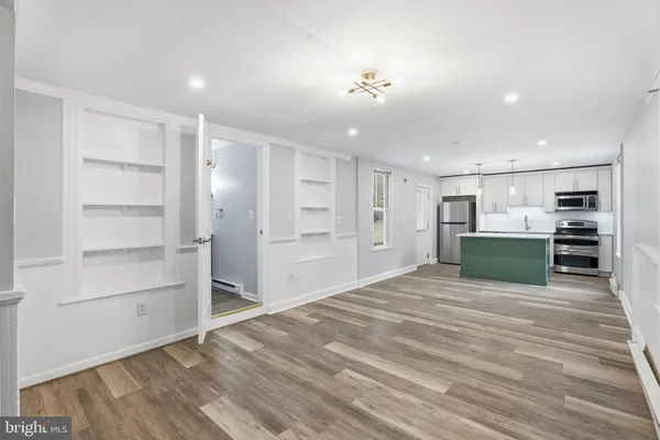 a view of a kitchen with wooden floor and electronic appliances