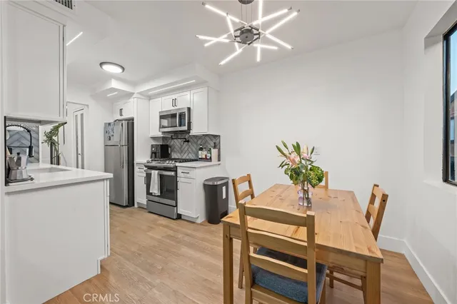 a kitchen with a table chairs refrigerator and microwave