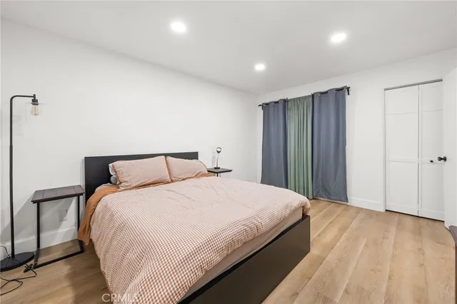 a large bed in a bedroom next to a cabinet