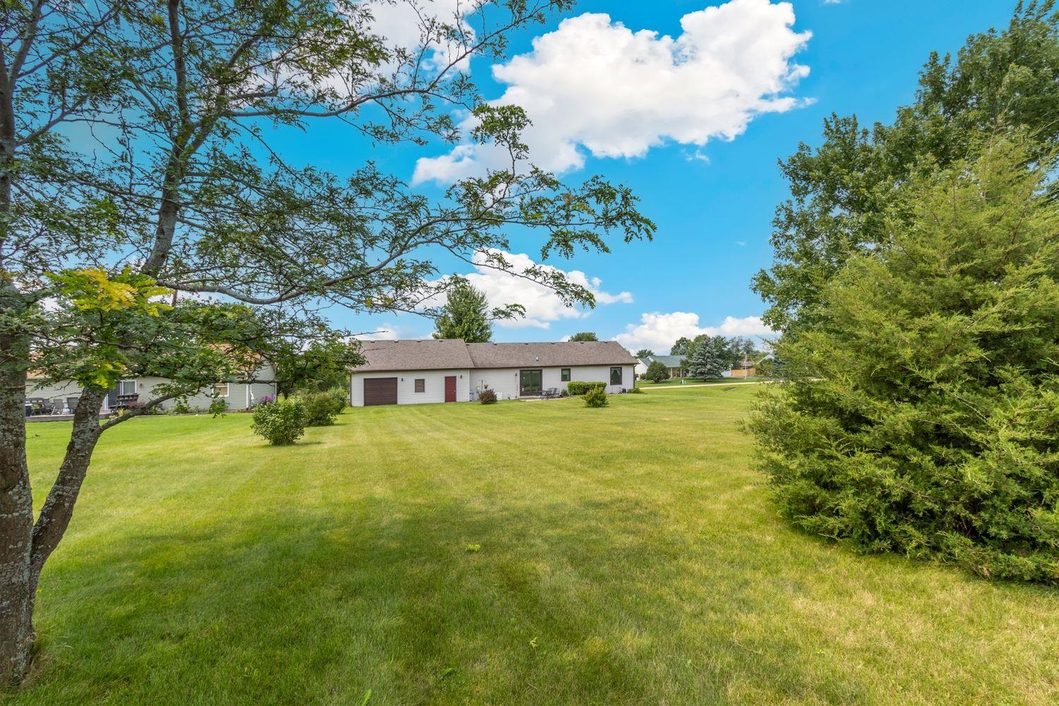 6771 Friday Road Byron, IL 61010 - Photo 4 of 25 a view of yellow house with a big yard and large trees