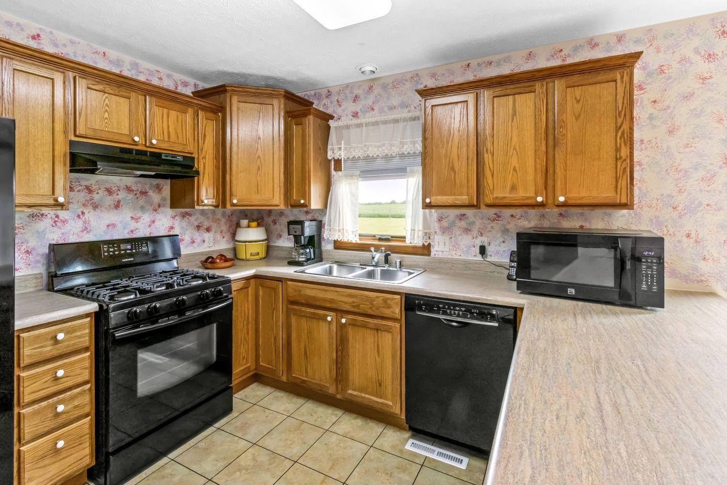 6771 Friday Road Byron, IL 61010 - Photo 7 of 25 a kitchen with stainless steel appliances granite countertop a stove a sink and a microwave