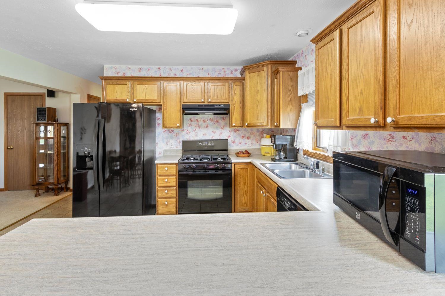 6771 Friday Road Byron, IL 61010 - Photo 8 of 25 a kitchen with stainless steel appliances granite countertop a refrigerator a stove and a sink