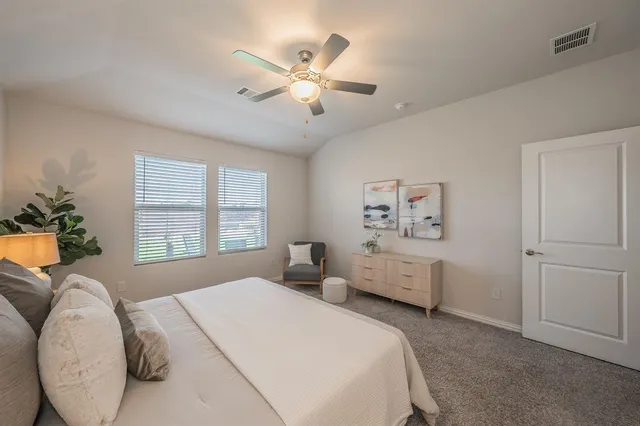a spacious bedroom with a large bed and a chandelier