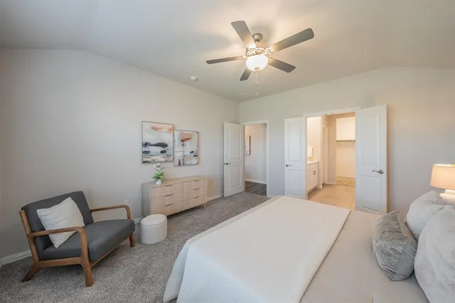 a spacious bedroom with a bed and a chandelier