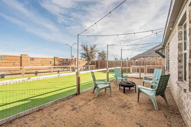 a view of a chair and tables in the back yard of the house