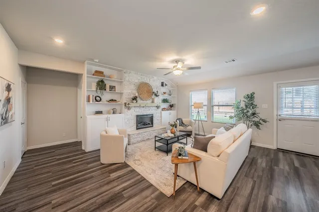 a living room with fireplace furniture and a wooden floor