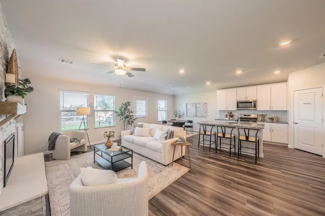 a living room with furniture kitchen and a table