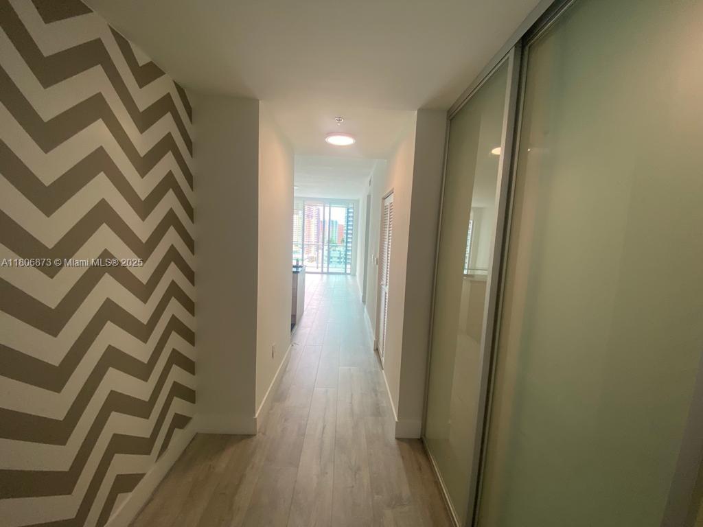 1111 Southwest 1st Avenue, Unit 2217N Miami, FL 33130 - Photo 7 of 14 a view of a hallway with wooden floor and staircase