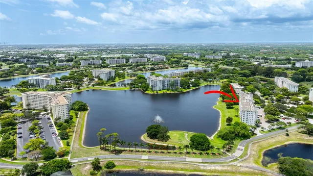 an aerial view of a house with a garden and lake view