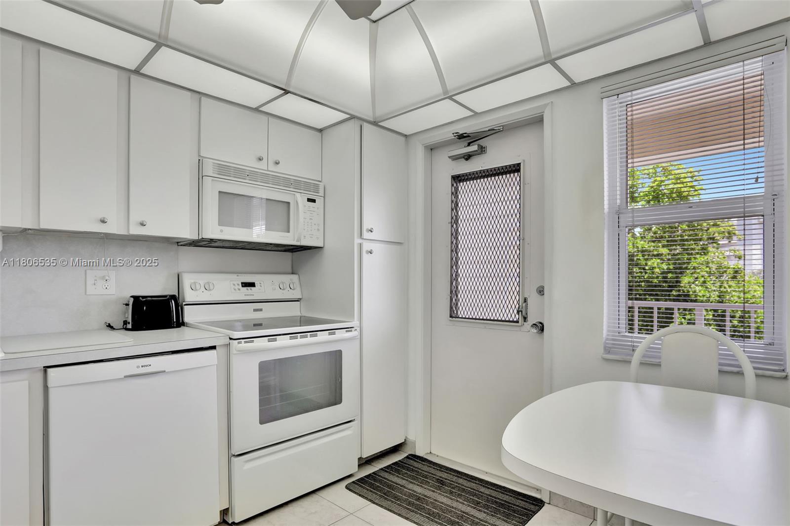 3091 North Course Drive, Unit 502 Pompano Beach, FL 33069 - Photo 4 of 42 a kitchen with stainless steel appliances granite countertop a sink a stove and white cabinets