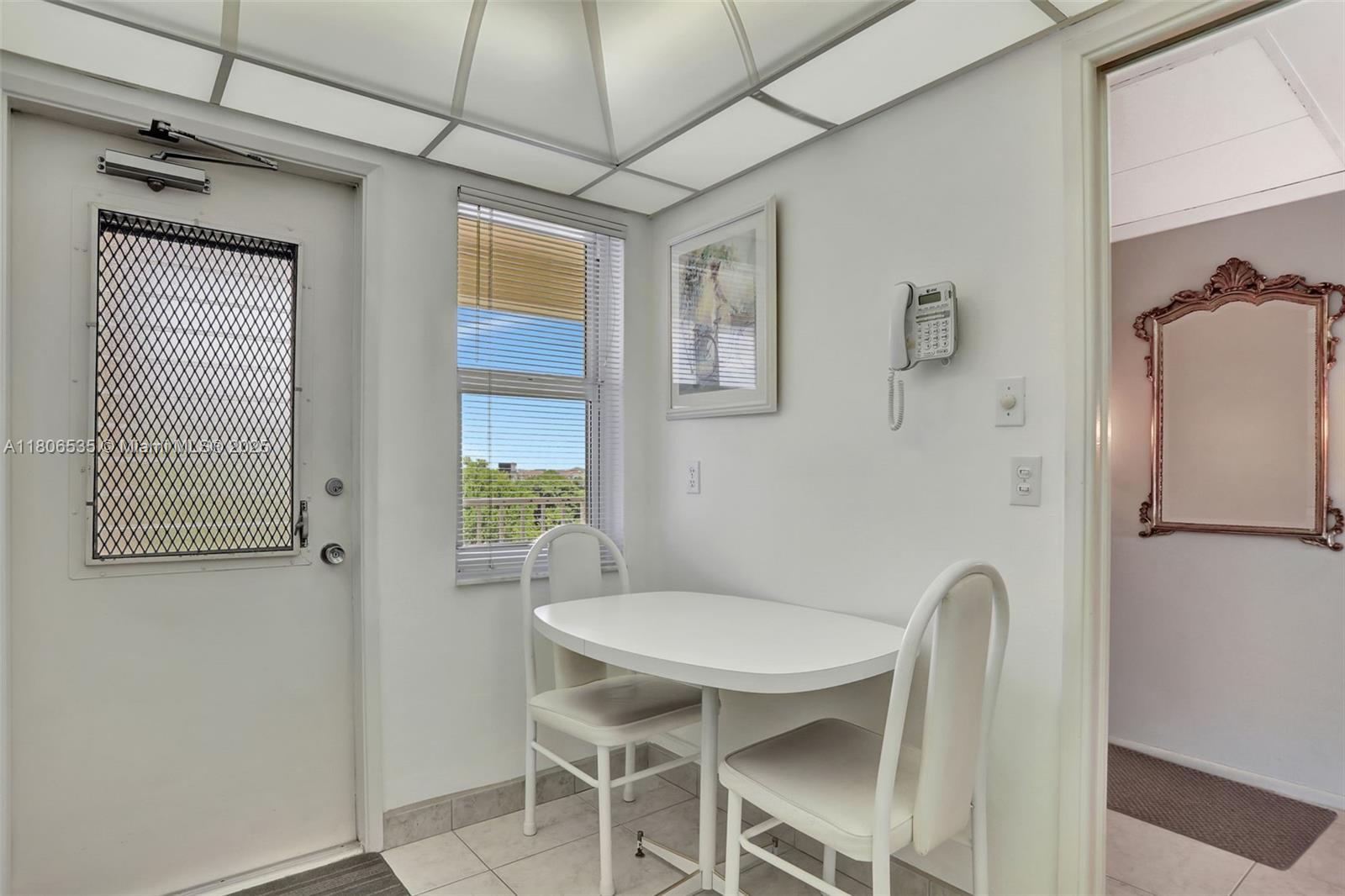 3091 North Course Drive, Unit 502 Pompano Beach, FL 33069 - Photo 6 of 42 a view of a dining room with furniture window and wooden floor