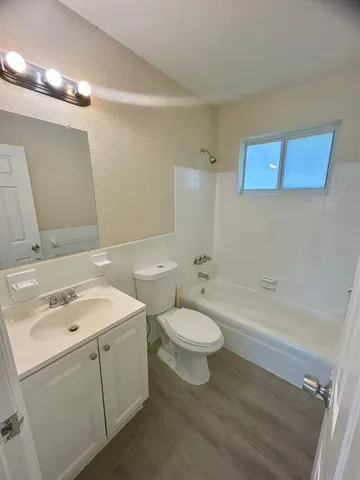 a bathroom with a toilet a sink a mirror and a bathtub
