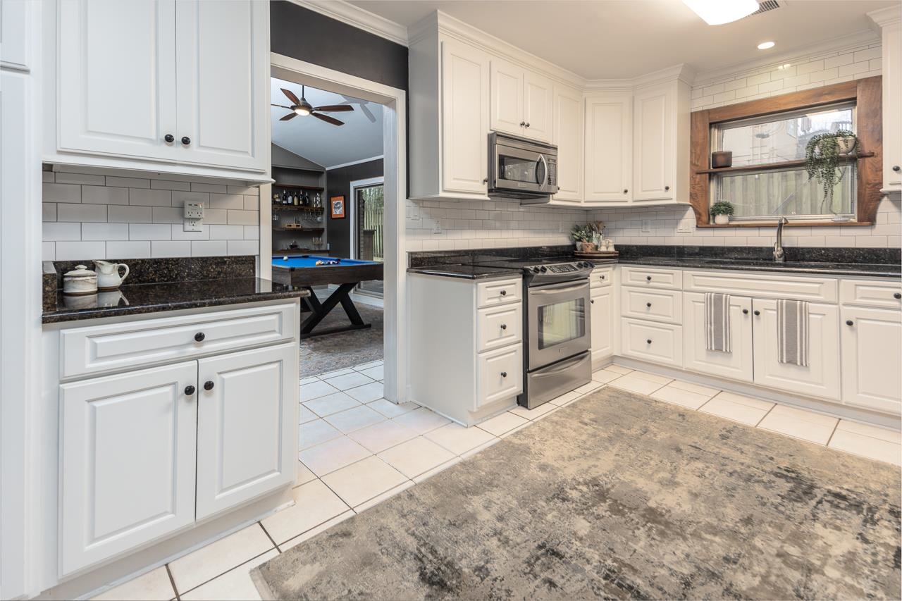 5641 Normandy Road Memphis, TN 38120 - Photo 8 of 25 a kitchen with stainless steel appliances granite countertop a stove sink and cabinets