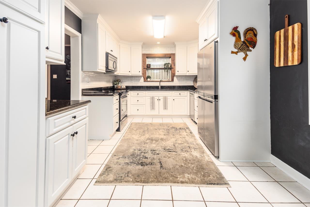 5641 Normandy Road Memphis, TN 38120 - Photo 10 of 25 a large white kitchen with cabinets and stainless steel appliances