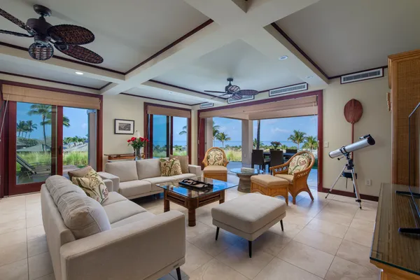a living room with furniture ceiling fan and a large window