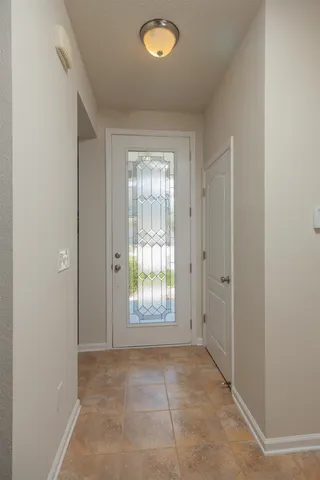 a spacious bedroom with a large bed a chandelier and windows