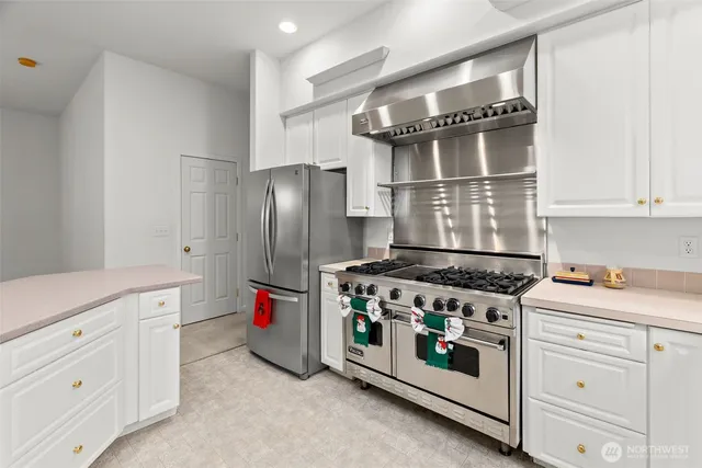 a kitchen with granite countertop a sink stove and cabinets