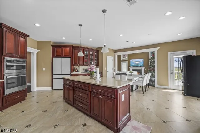 a kitchen with stainless steel appliances kitchen island granite countertop a refrigerator and a sink