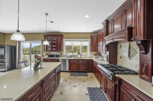 a kitchen with stainless steel appliances granite countertop a stove a sink and a refrigerator