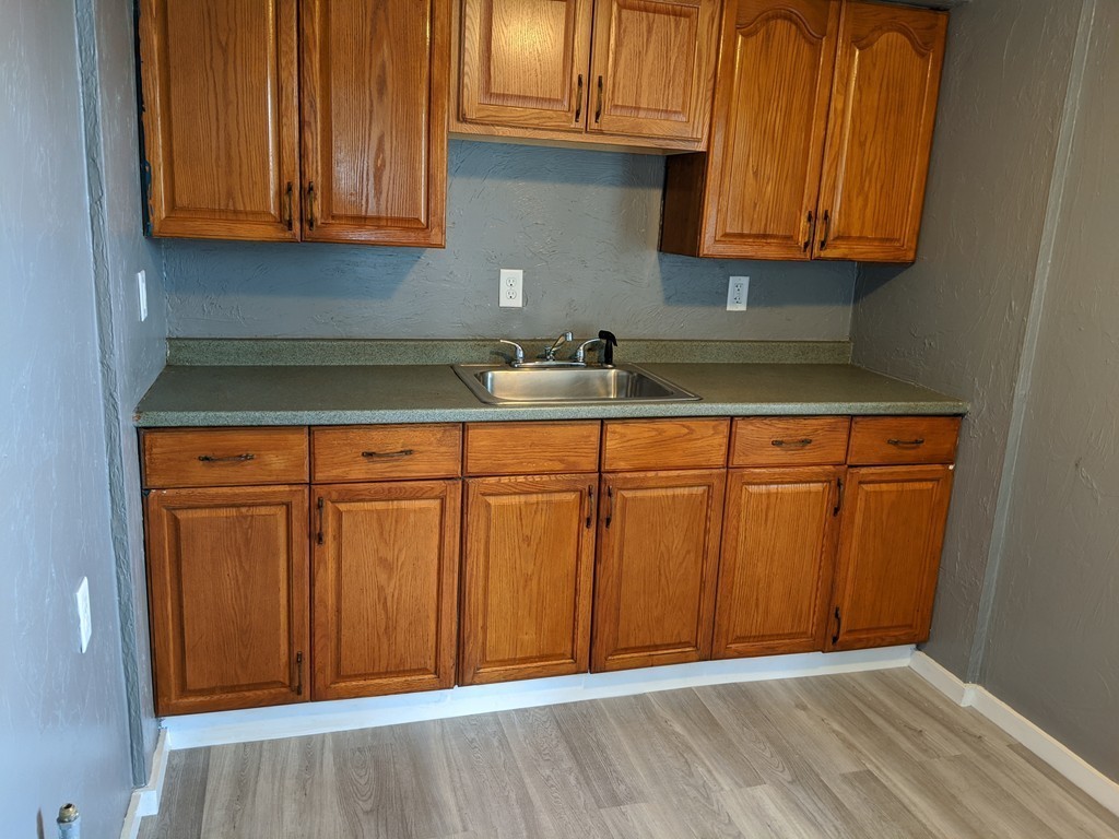 655 Grinnell Street Fall River, MA 02721 - Photo 4 of 24 a kitchen with granite countertop wooden cabinets and a sink