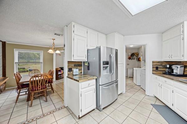 1816 Caddo Peak Road Joshua, TX 76058 - Photo 11 of 38 a kitchen with white cabinets and stainless steel appliances
