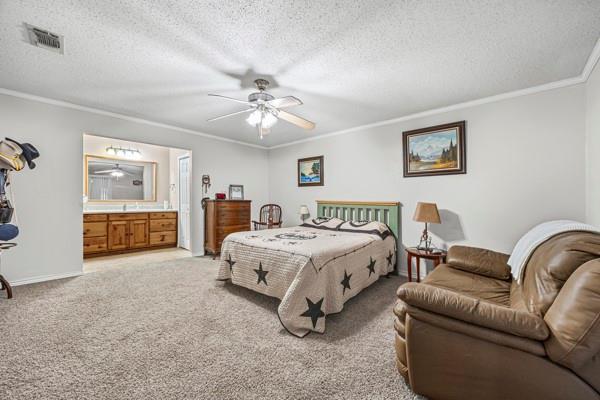 1816 Caddo Peak Road Joshua, TX 76058 - Photo 18 of 38 a spacious bedroom with a bed a couch and a chandelier