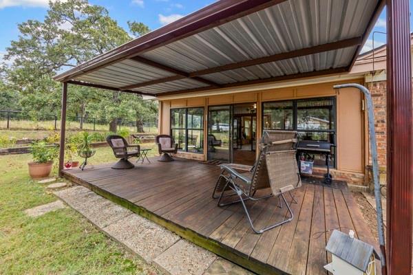 1816 Caddo Peak Road Joshua, TX 76058 - Photo 33 of 38 a view of a patio with table and chairs potted plants with wooden floor and floor to ceiling window
