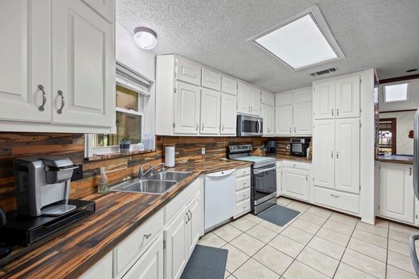 1816 Caddo Peak Road Joshua, TX 76058 - Photo 5 of 38 a kitchen with kitchen island granite countertop a sink and white cabinets