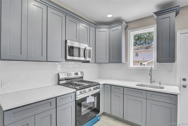 a kitchen with stainless steel appliances white cabinets and a stove top oven