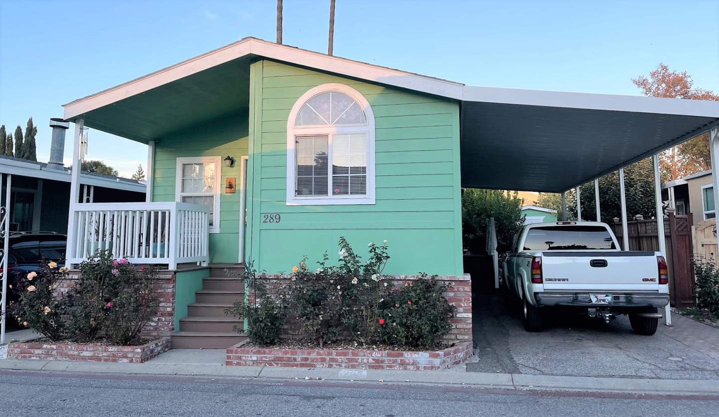 a view of a house with a car parked beside it