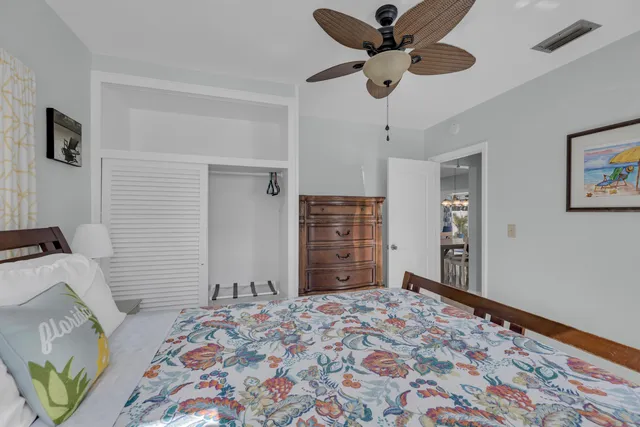 a bedroom with a bed dresser and a chandelier