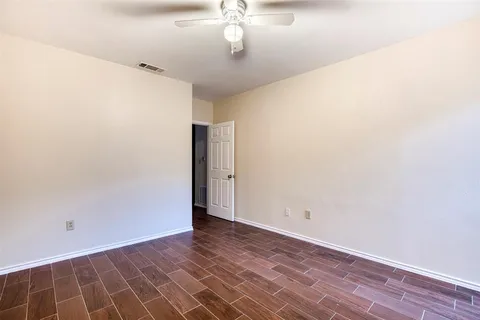 a view of an empty room with wooden floor
