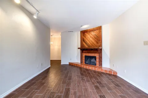 a view of empty room with wooden floor and fireplace