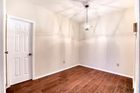 a view of a room with wooden floor and white walls