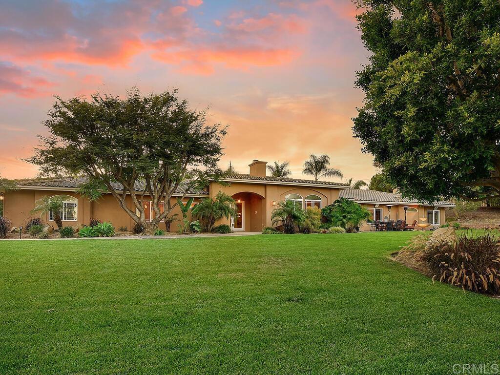 a front view of a house with a yard and trees