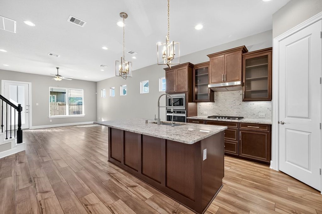 4209 Colony Pines Lane Houston, TX 77080 - Photo 7 of 30 a kitchen with stainless steel appliances granite countertop a sink a stove and a wooden floors