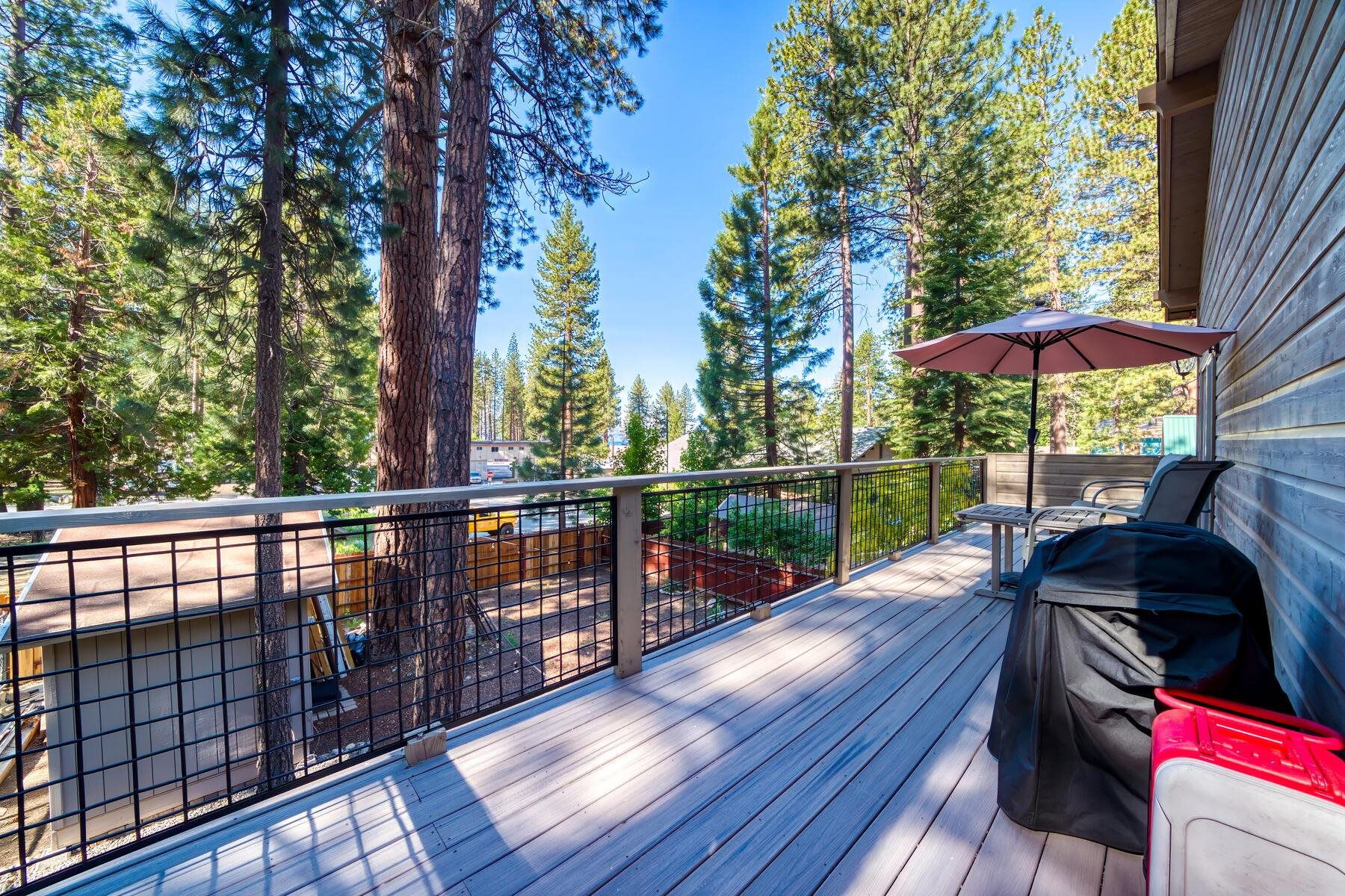 8666 Brook Avenue Kings Beach, CA 96143 - Photo 11 of 21 a view of a deck with two chair under an umbrella with wooden floor