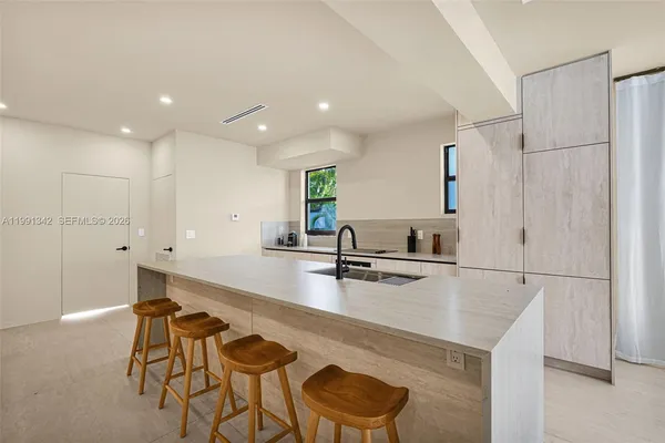 a kitchen with stainless steel appliances granite countertop a sink and a refrigerator
