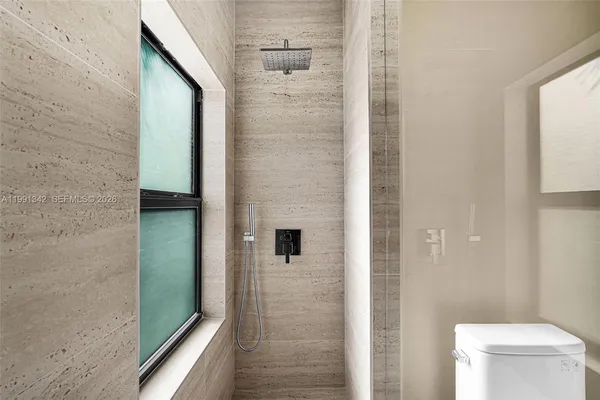 a bathroom with a toilet and a shower