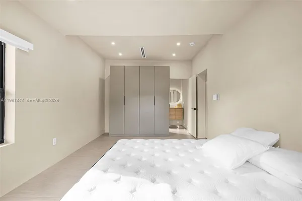 a large bedroom with a bed and a large mirror