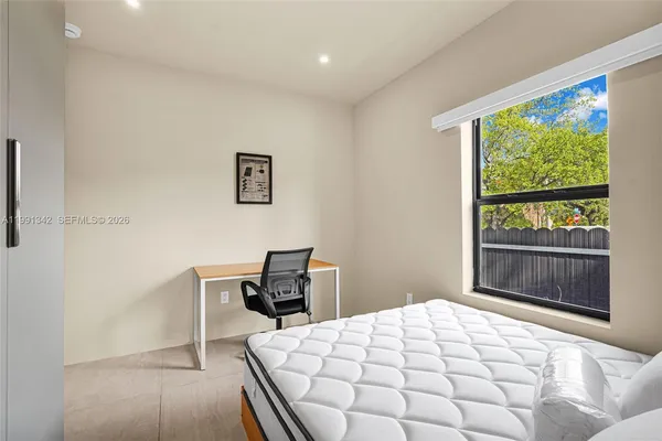 a bedroom with a bed and a window