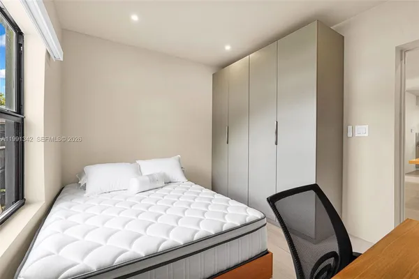 a bedroom with a bed and mirror