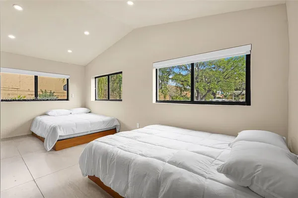 a bedroom with two beds and a large window