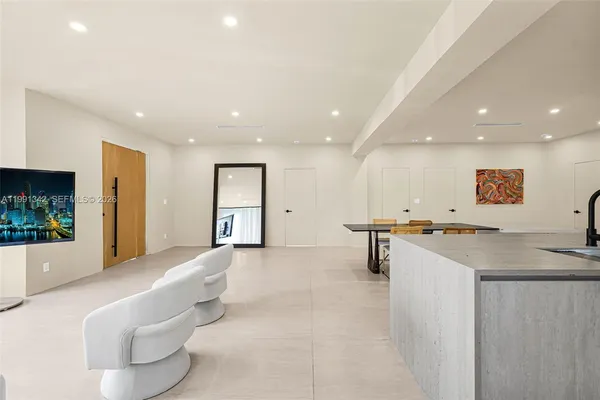 a open kitchen with kitchen island a sink a stove a dining table and chairs