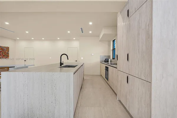 a view of a kitchen with kitchen island and stainless steel appliances