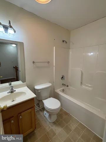 a bathroom with a sink a toilet a mirror and shower