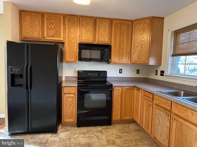 a kitchen with granite countertop wooden cabinets and stainless steel appliances
