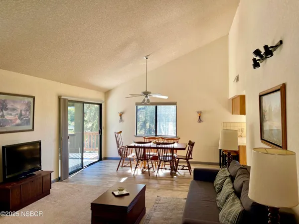 a living room with furniture a flat screen tv and a window