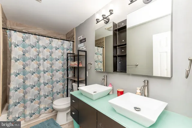 a bathroom with a sink toilet vanity and shower